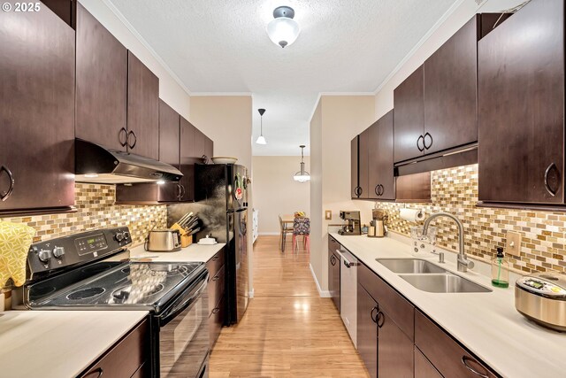 4320 S Corbett Ave Unit 302, Portland, OR 97239 - kitchen featuring black appliances, under cabinet range hood, a sink, light wood-style flooring, and light countertops
