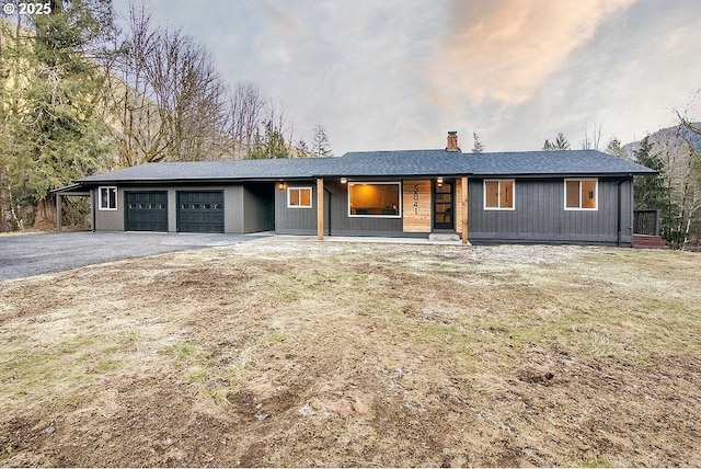 ranch-style home with a garage and covered porch