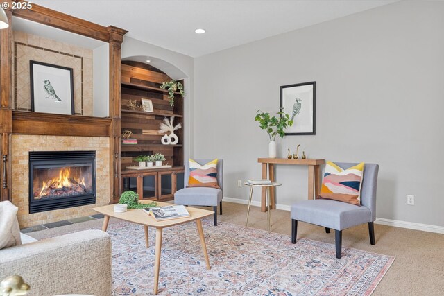 sitting room with baseboards, carpet, a fireplace, recessed lighting, and built in features