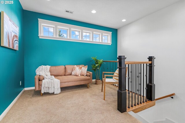living area featuring an upstairs landing, carpet floors, baseboards, and recessed lighting