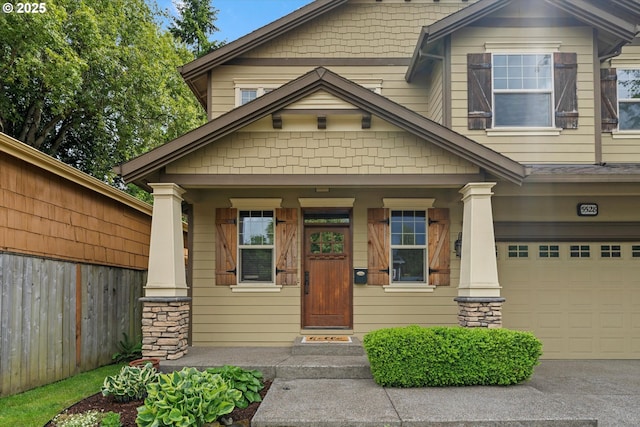 view of front facade with an attached garage, fence, covered porch, and driveway