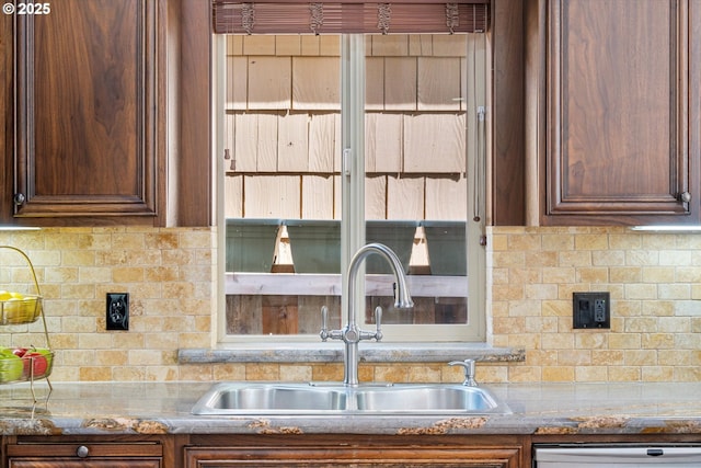 kitchen with a sink, backsplash, and dishwashing machine