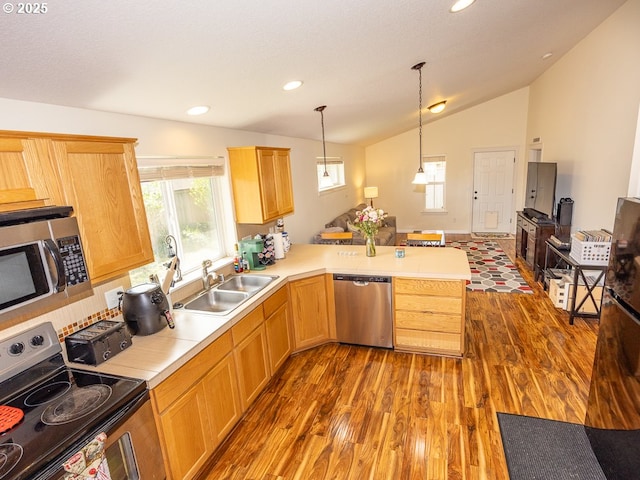13311 NE 50th Way, Vancouver, WA 98682 - kitchen featuring appliances with stainless steel finishes, a sink, dark wood finished floors, lofted ceiling, and a peninsula