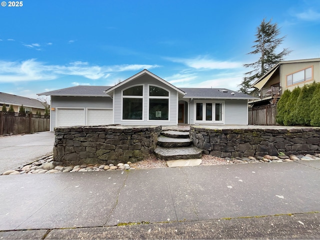 view of front of house with a garage, fence, and concrete driveway