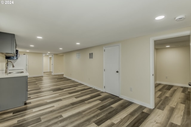 basement with wood-type flooring and sink