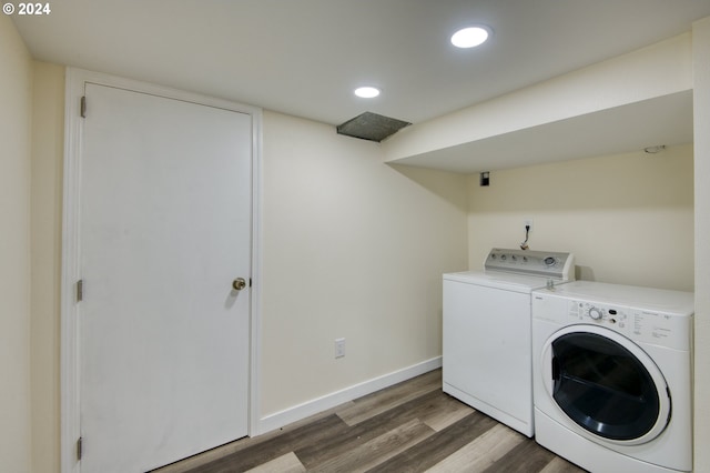 washroom with dark hardwood / wood-style flooring and washer and clothes dryer