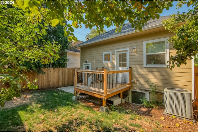 rear view of property with a deck, a yard, and central AC unit