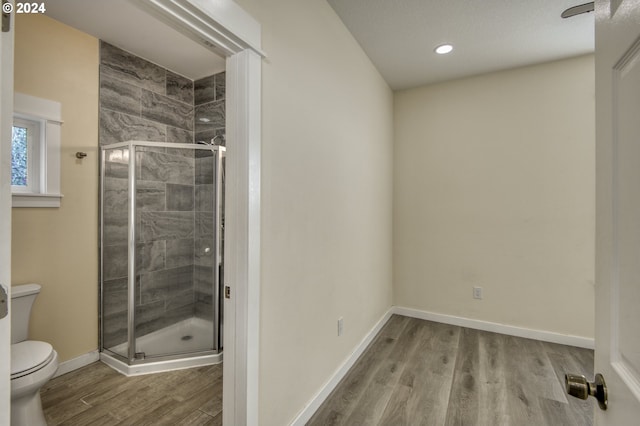 bathroom with walk in shower, wood-type flooring, and toilet