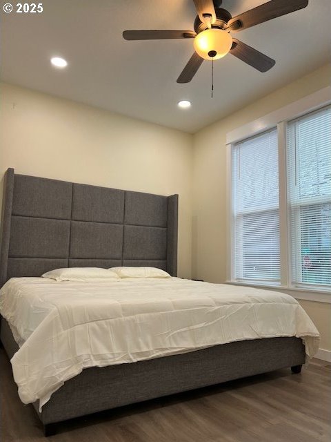 bedroom with dark hardwood / wood-style flooring and ceiling fan