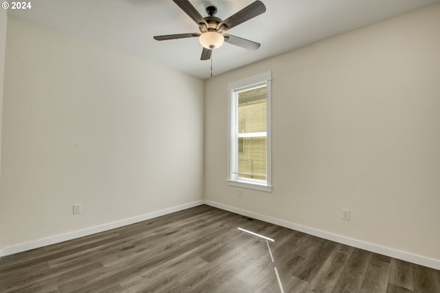 empty room with dark hardwood / wood-style floors and ceiling fan