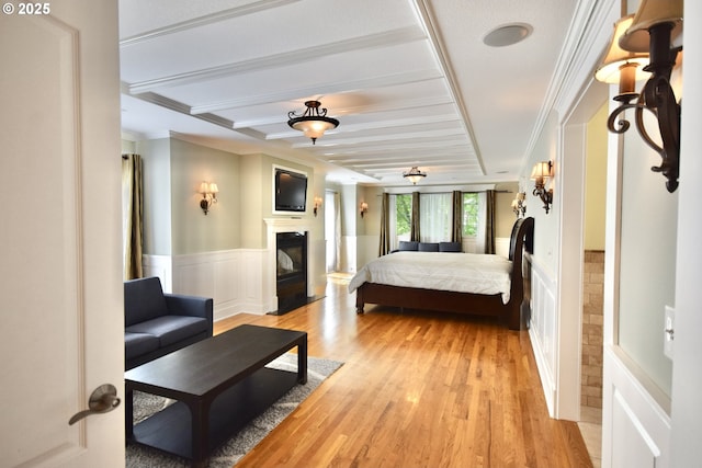 2917 NE 9th Ave, Portland, OR 97212 - bedroom with wainscoting, light wood finished floors, beamed ceiling, ornamental molding, and a glass covered fireplace