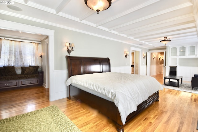 2917 NE 9th Ave, Portland, OR 97212 - bedroom with light wood-type flooring, a decorative wall, crown molding, a wainscoted wall, and beam ceiling