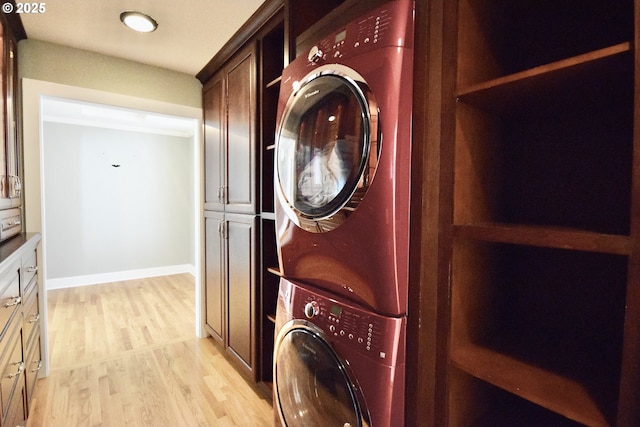 2917 NE 9th Ave, Portland, OR 97212 - washroom with stacked washer / drying machine, cabinet space, and light wood-style floors