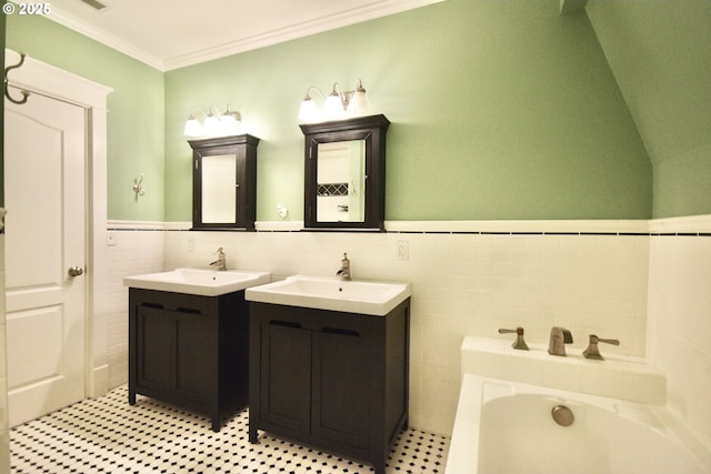 2917 NE 9th Ave, Portland, OR 97212 - bathroom with tile walls, two vanities, a bath, ornamental molding, and a wainscoted wall
