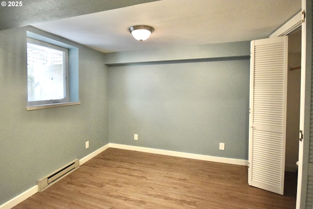 2917 NE 9th Ave, Portland, OR 97212 - unfurnished bedroom with a baseboard radiator, wood finished floors, baseboards, and a closet