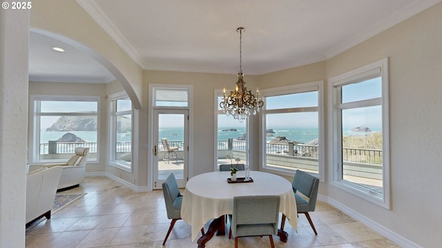 96424 Shorewood Ter, Brookings, OR 97415 - dining room featuring crown molding, a water view, light tile patterned floors, arched walkways, and an inviting chandelier