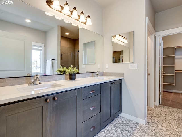 full bathroom featuring baseboards, a sink, double vanity, and a stall shower