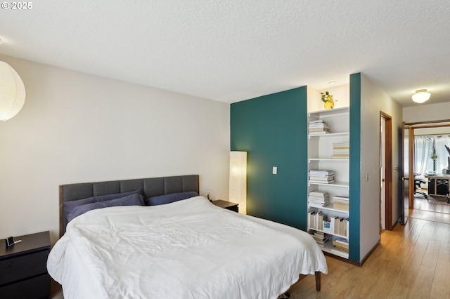 12604 NE Prescott Dr, Portland, OR 97230 - bedroom featuring light wood-style flooring, a textured ceiling, and a closet