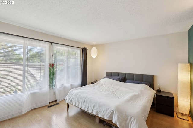 12604 NE Prescott Dr, Portland, OR 97230 - bedroom featuring a textured ceiling and light wood-style floors