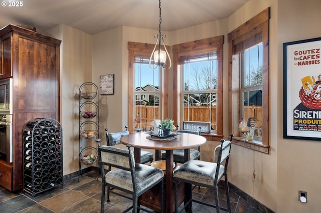 dining area with baseboards and stone tile floors