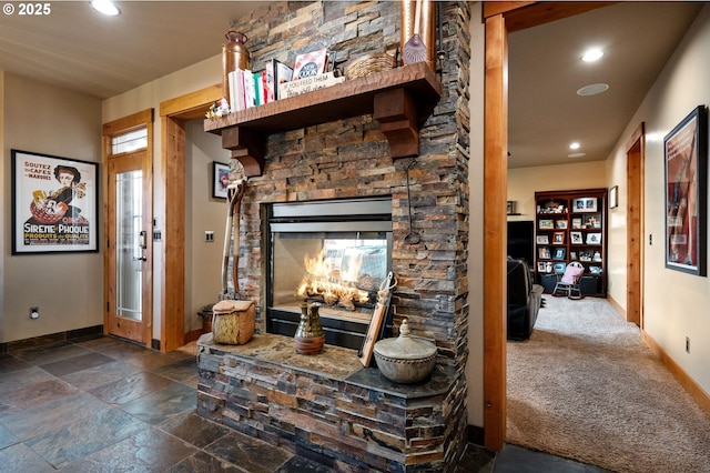 living area with recessed lighting, stone finish floor, a fireplace, and baseboards