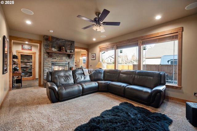 living room with a ceiling fan, recessed lighting, a stone fireplace, and baseboards