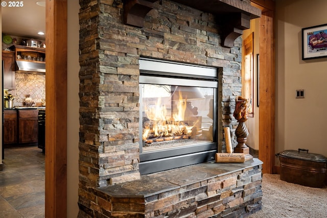 interior details with range hood, bar area, a fireplace, and backsplash