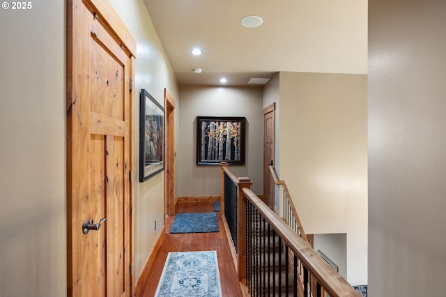 hall with recessed lighting, baseboards, an upstairs landing, and wood finished floors