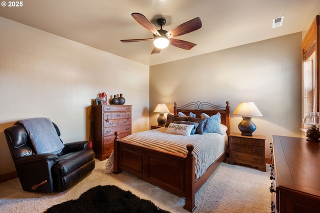 bedroom with visible vents, a ceiling fan, and light colored carpet