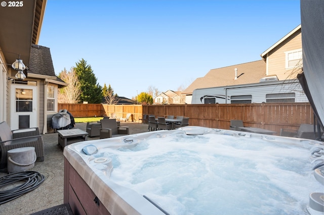 view of patio featuring a hot tub, a fenced backyard, grilling area, outdoor dining area, and outdoor lounge area