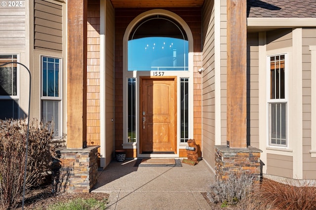 entrance to property featuring a shingled roof