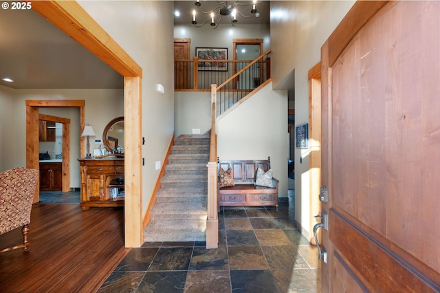 interior space featuring stairway, stone finish floor, and a high ceiling