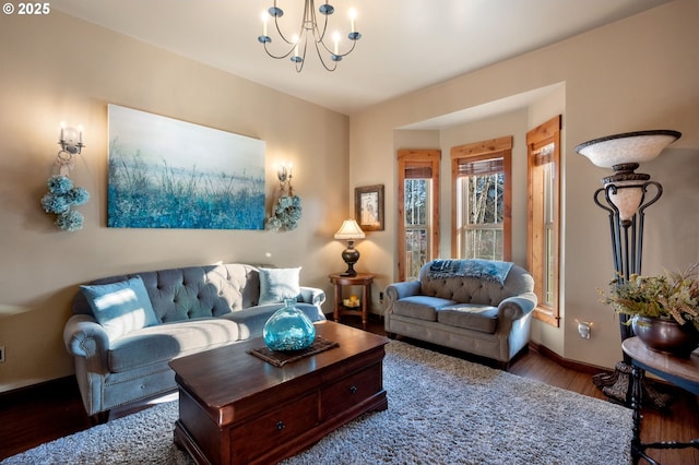 living area with a notable chandelier, baseboards, and wood finished floors