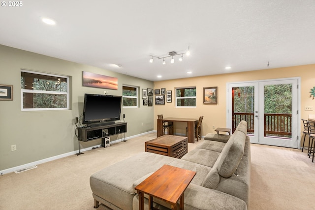 carpeted living room featuring french doors and track lighting