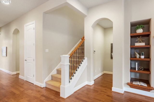 stairway with hardwood / wood-style floors