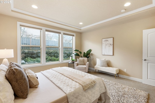 carpeted bedroom featuring a raised ceiling and crown molding