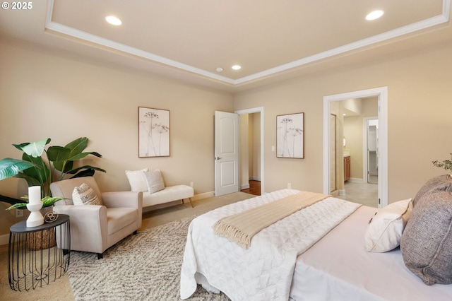 bedroom with connected bathroom, crown molding, and a raised ceiling