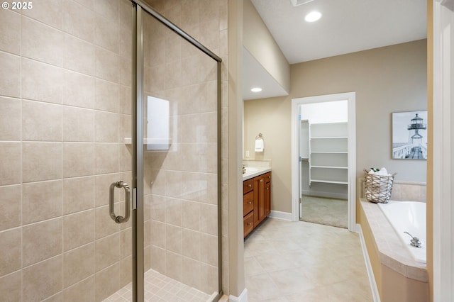 bathroom featuring vanity, plus walk in shower, and tile patterned flooring