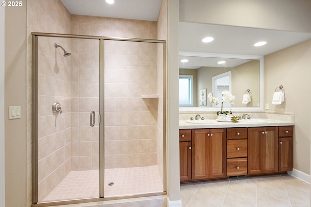 bathroom featuring vanity, a shower with shower door, and tile patterned floors