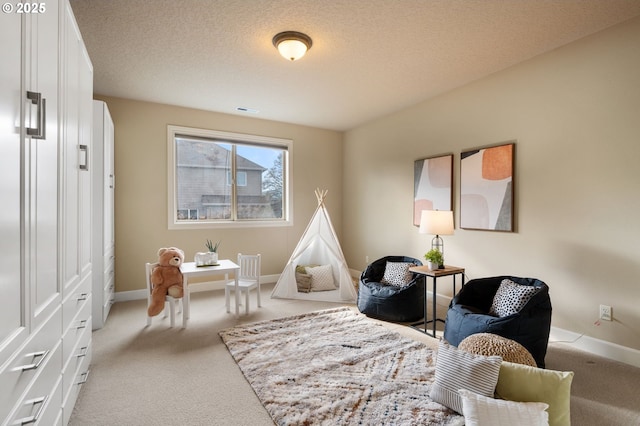 living area featuring light carpet and a textured ceiling