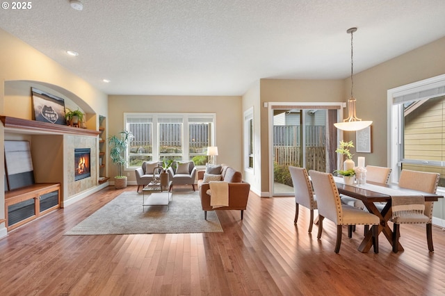 living room with hardwood / wood-style flooring, a fireplace, and a textured ceiling