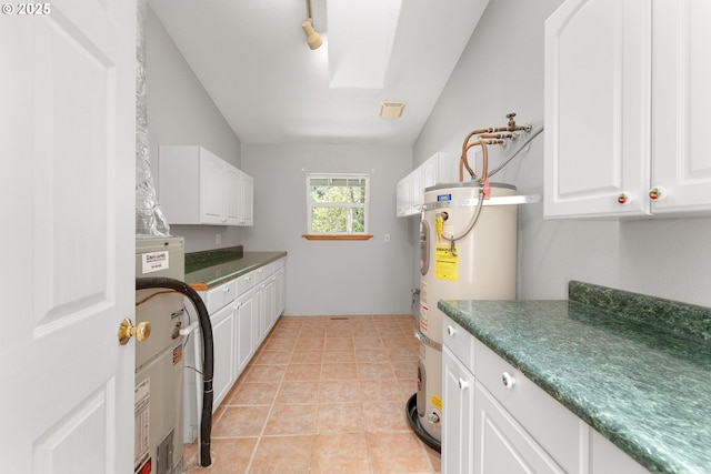 washroom featuring cabinet space and water heater