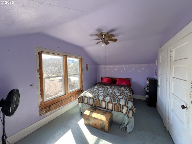 bedroom featuring lofted ceiling, a textured ceiling, a ceiling fan, and baseboards