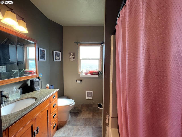 full bath with toilet, stone finish floor, a shower with shower curtain, and vanity