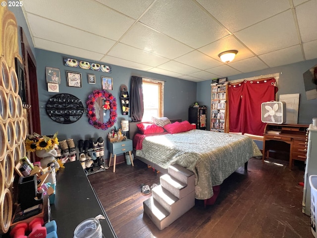 bedroom with a paneled ceiling and wood-type flooring