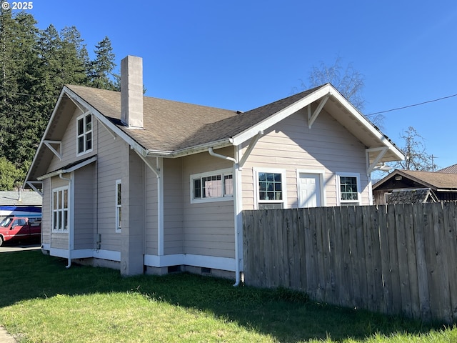 view of home's exterior featuring crawl space, fence, a chimney, and a lawn