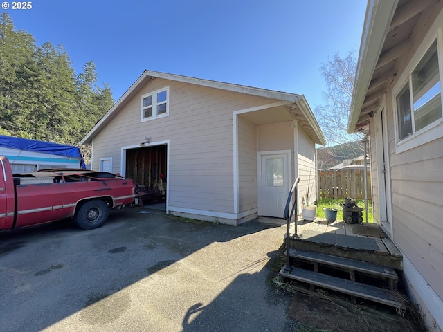 exterior space featuring a garage, driveway, and fence