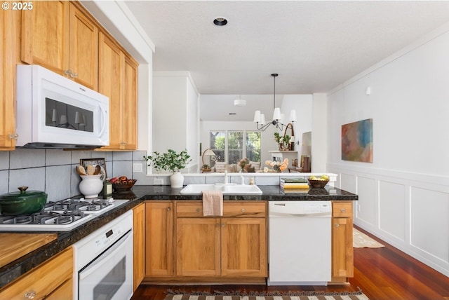 884 NE 73rd Ave, Hillsboro, OR 97124 - kitchen featuring white appliances, a peninsula, a chandelier, dark wood finished floors, and backsplash