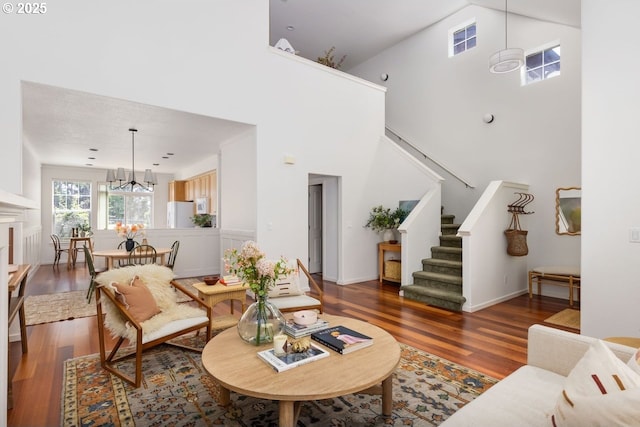 884 NE 73rd Ave, Hillsboro, OR 97124 - living room featuring a towering ceiling, stairs, wood finished floors, and a chandelier