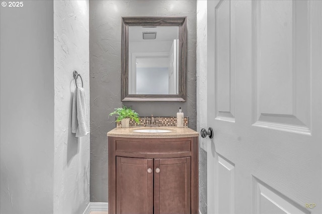 bathroom featuring vanity and backsplash